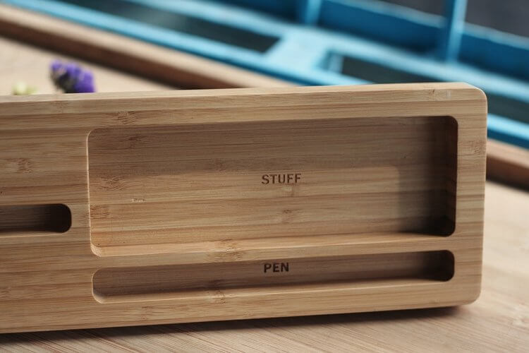 Close-up of a bamboo desktop organizer with labeled compartments for 'STUFF' and 'PEN', ideal for eco-friendly desk storage.