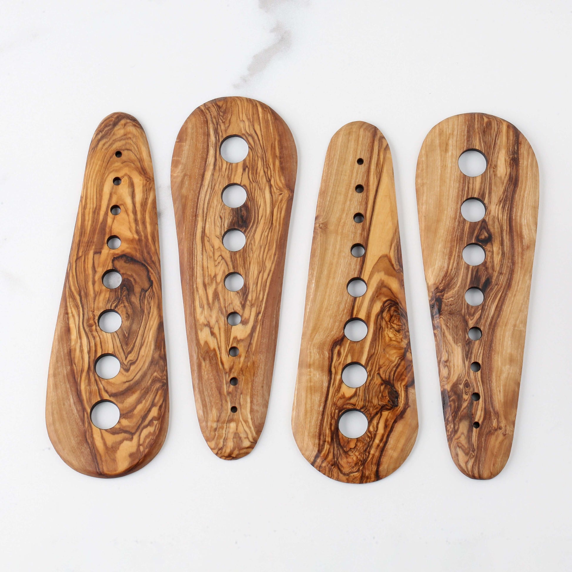 Handmade olive wood herb stripper tools with multiple sized holes for easy leaf removal of herbs.