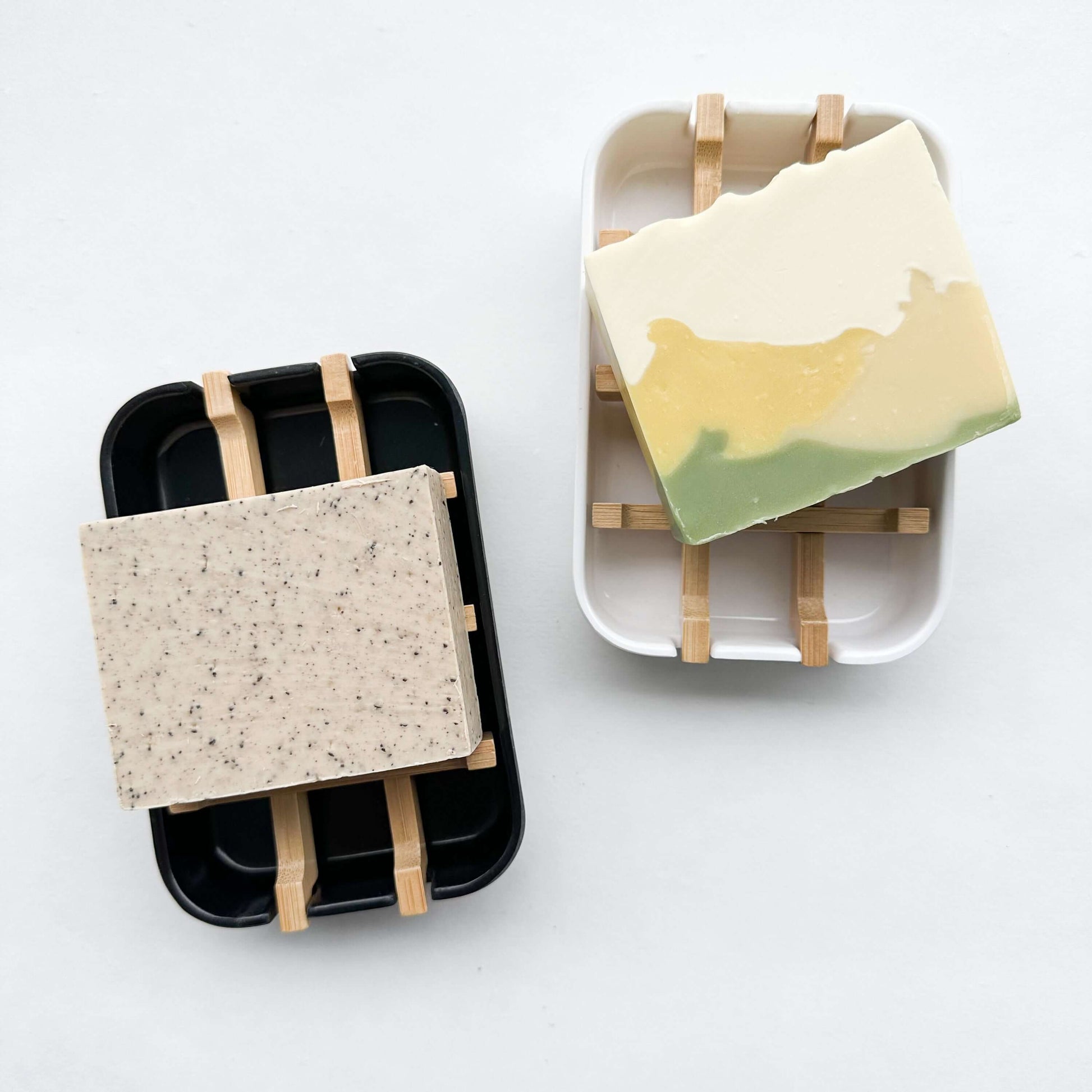 Biodegradable bamboo and cornstarch soap dishes holding colorful soap bars, perfect for zero waste living.