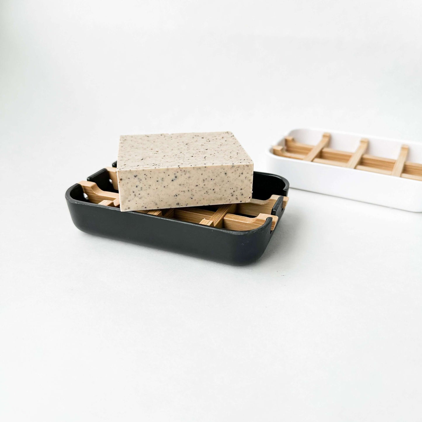 Biodegradable bamboo and cornstarch soap dish with soap bar, eco-friendly and plastic-free design.