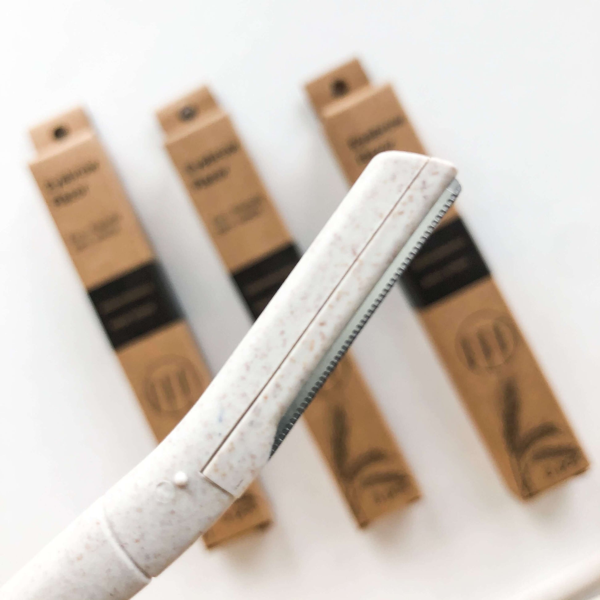 Biodegradable wheat straw eyebrow razor trimmer with eco-friendly packaging for flawless brows and skincare.