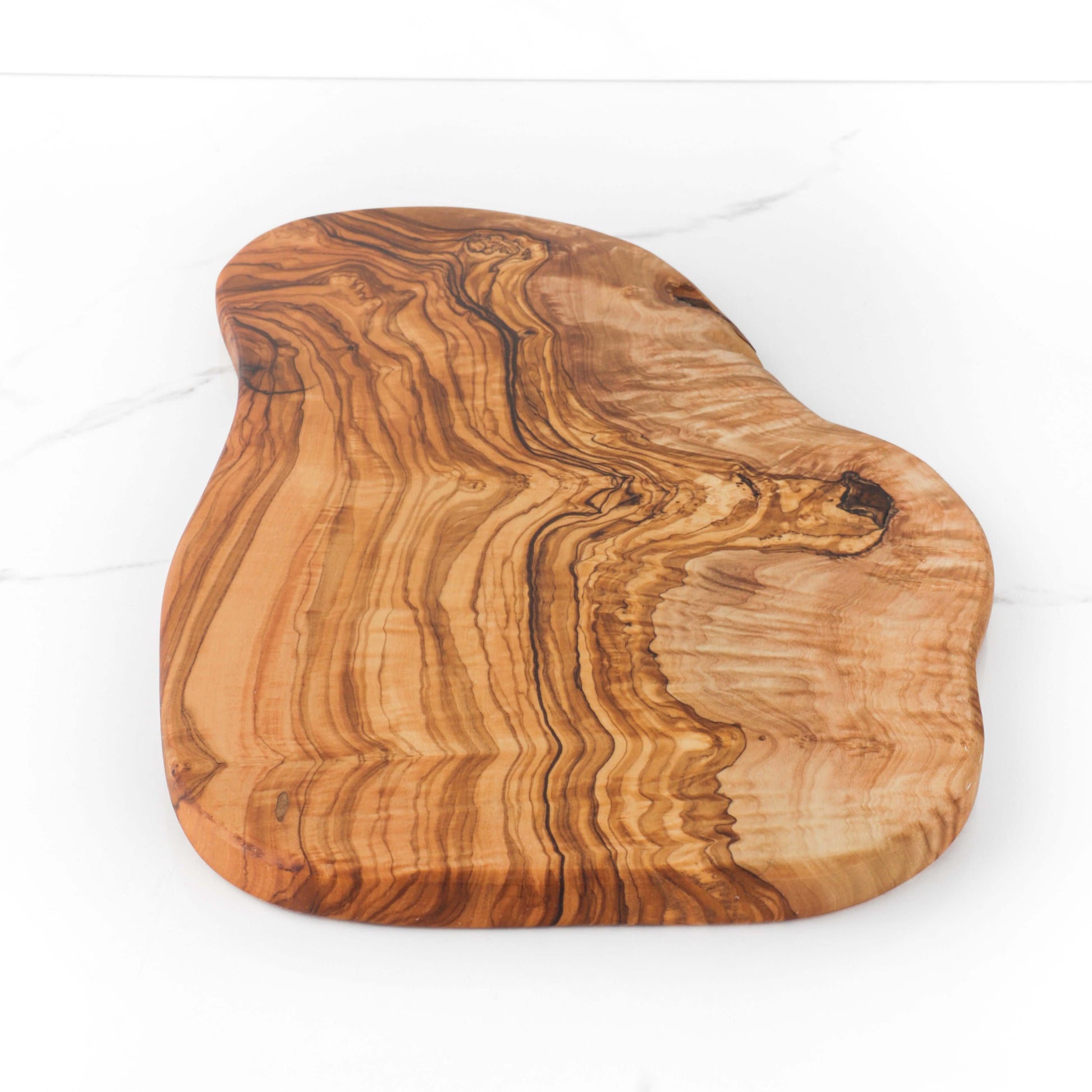 Handmade rustic olive wood cutting board with natural edges, showcasing unique patterns and sturdy surface.