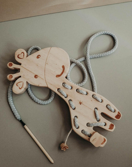 Giraffe lacing toy made of pinewood with cotton cord, promoting pre-writing skills and hand-eye coordination.