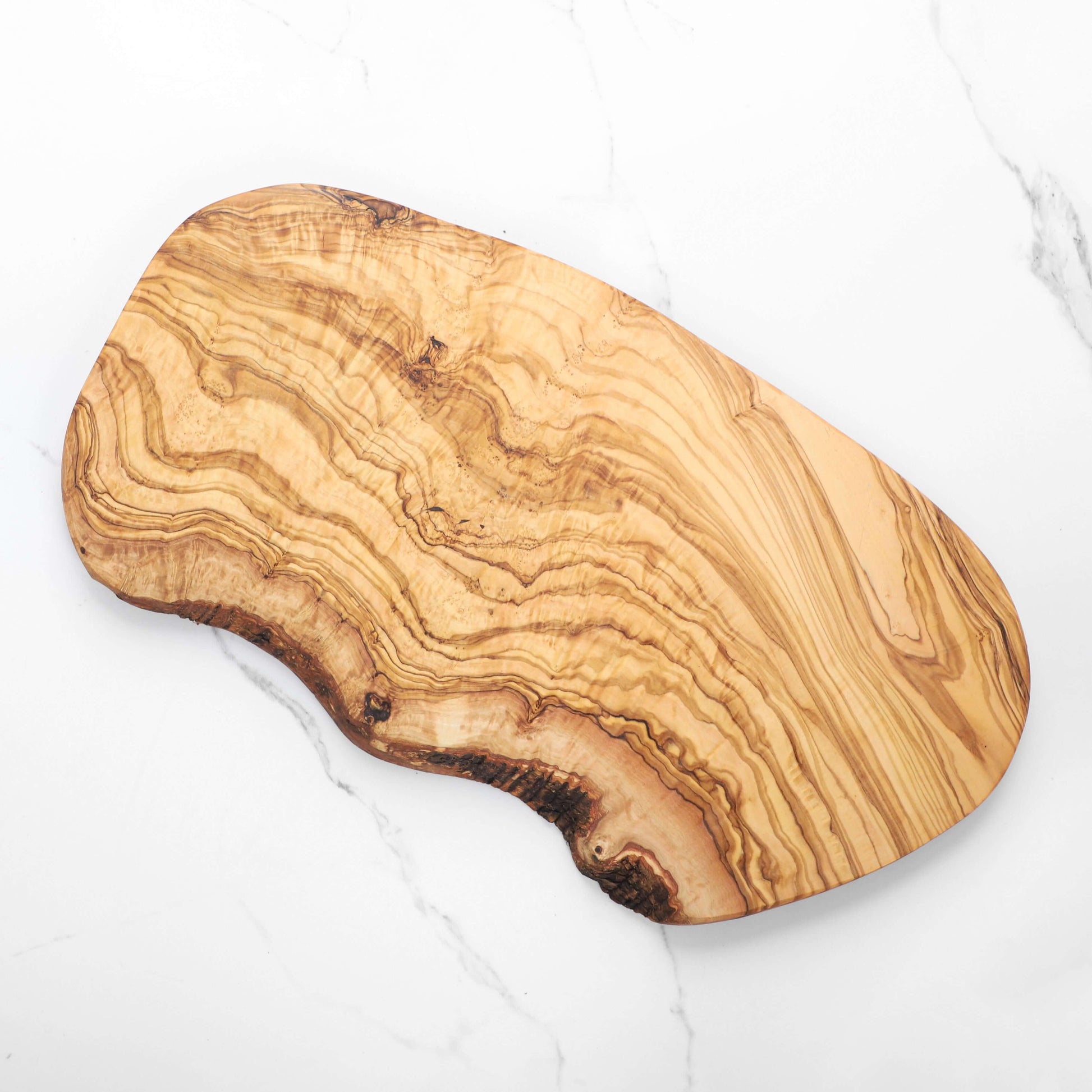 Handmade olive wood cutting board featuring unique natural edges and beautiful grain patterns.