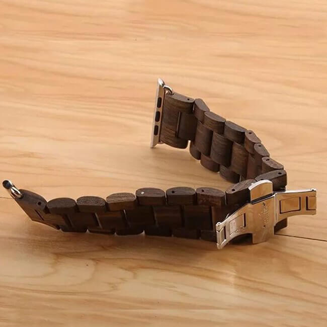Handmade wooden Apple Watch band made of natural ebony wood, showcasing intricate grain patterns and a secure metal clasp.
