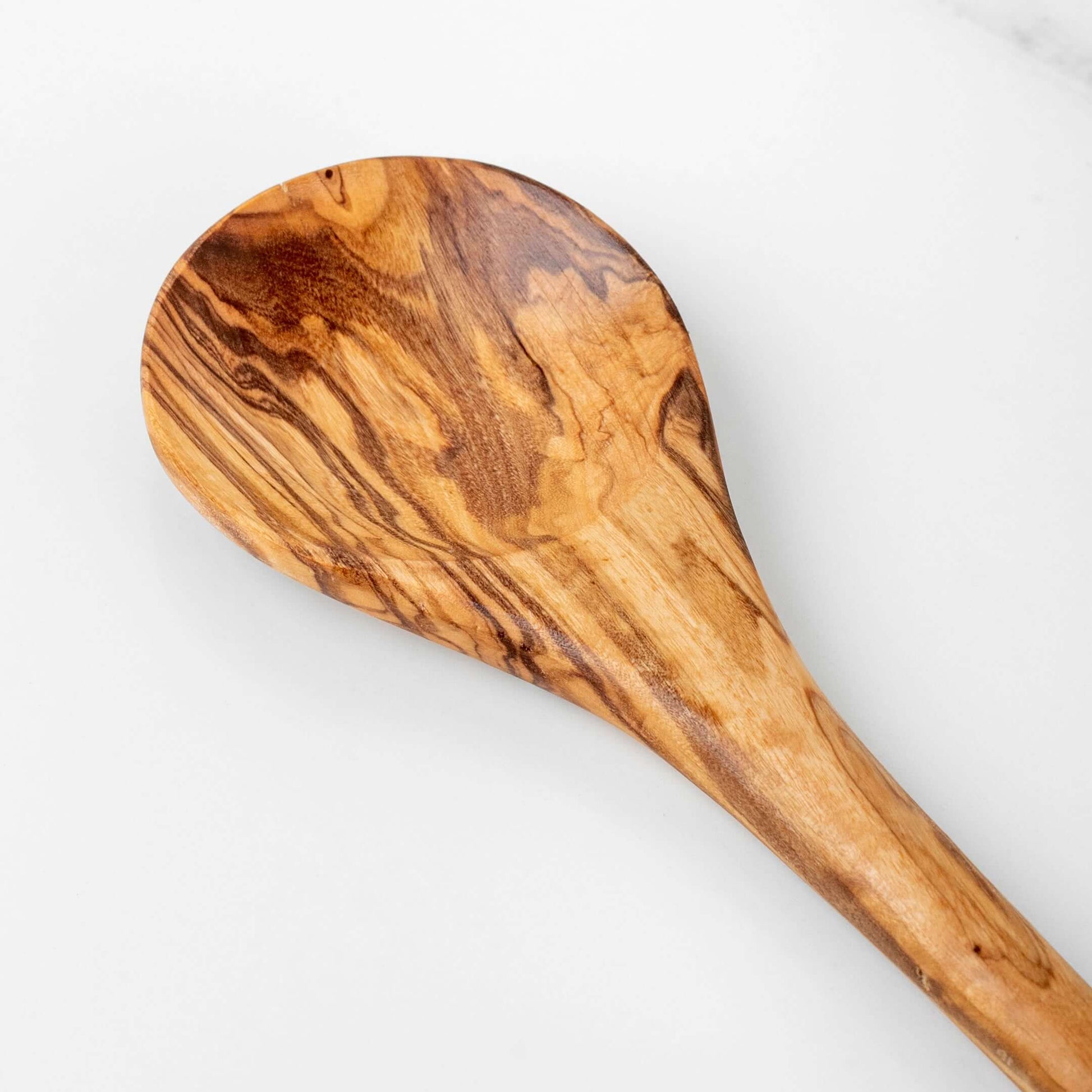 Handmade olive wood stirring spoon top view, showcasing unique grain pattern and smooth finish, ideal for cooking.