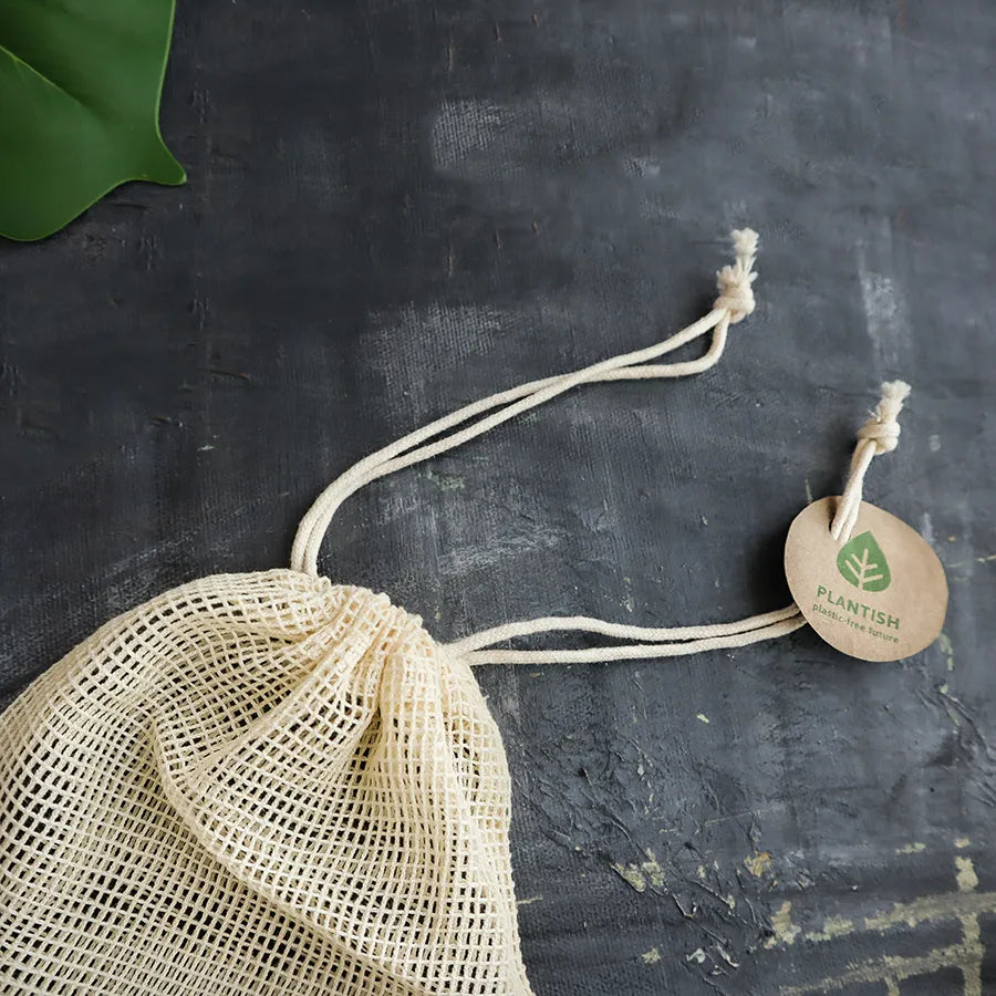 Natural mesh bag for reusable cotton makeup removal rounds with drawstring closure and eco-friendly tag.