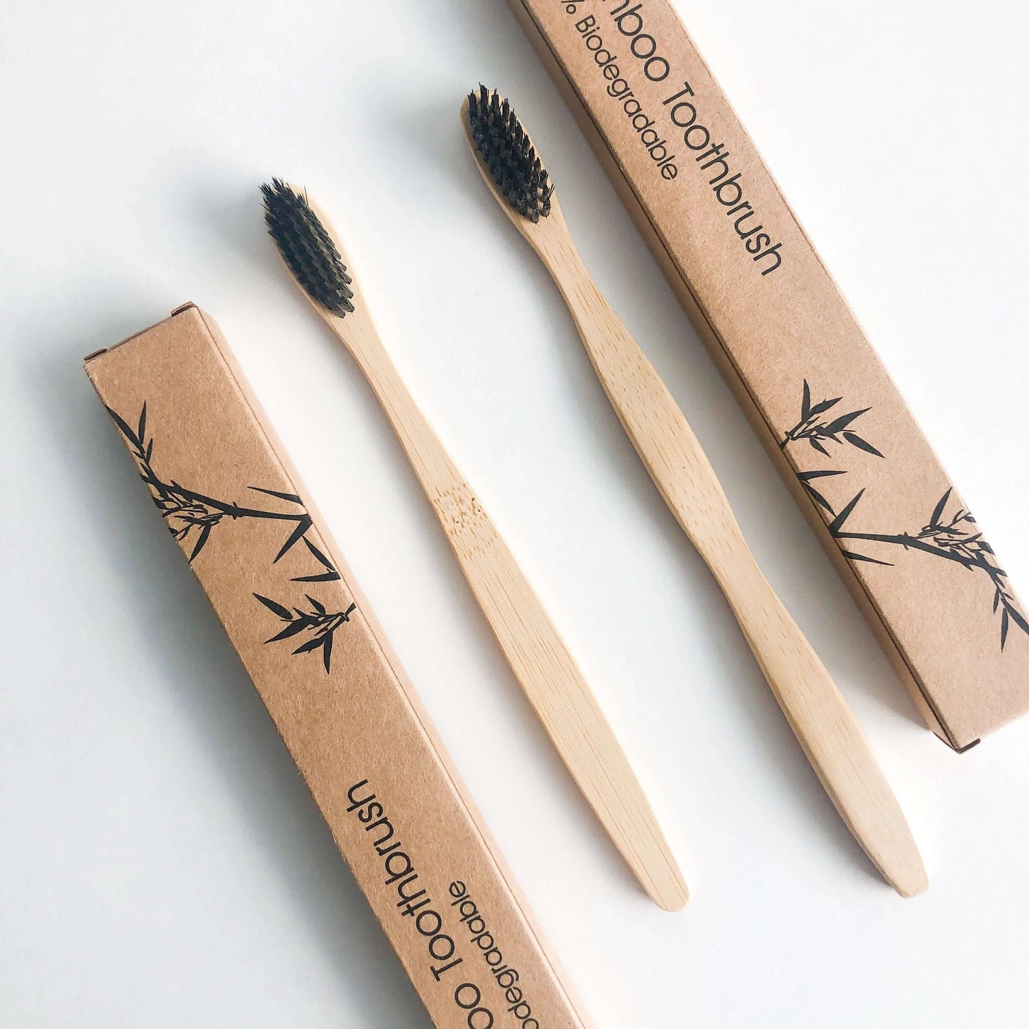 Eco friendly bamboo toothbrush with charcoal bristles in biodegradable packaging for a sustainable oral care.
