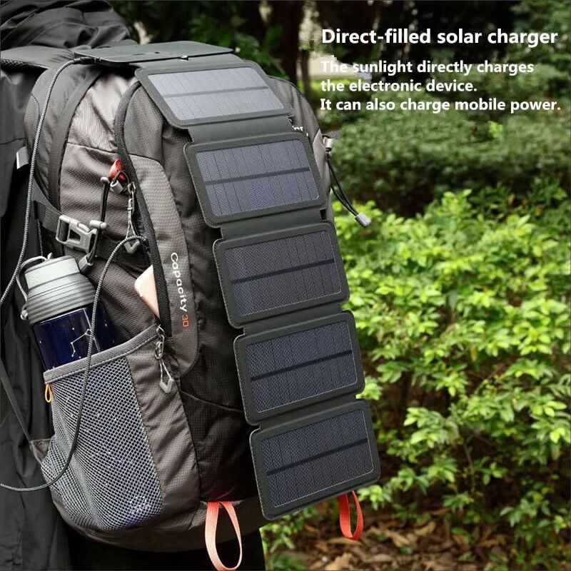 Folding solar charger attached to a backpack, utilizing direct sunlight to power electronic devices outdoors.