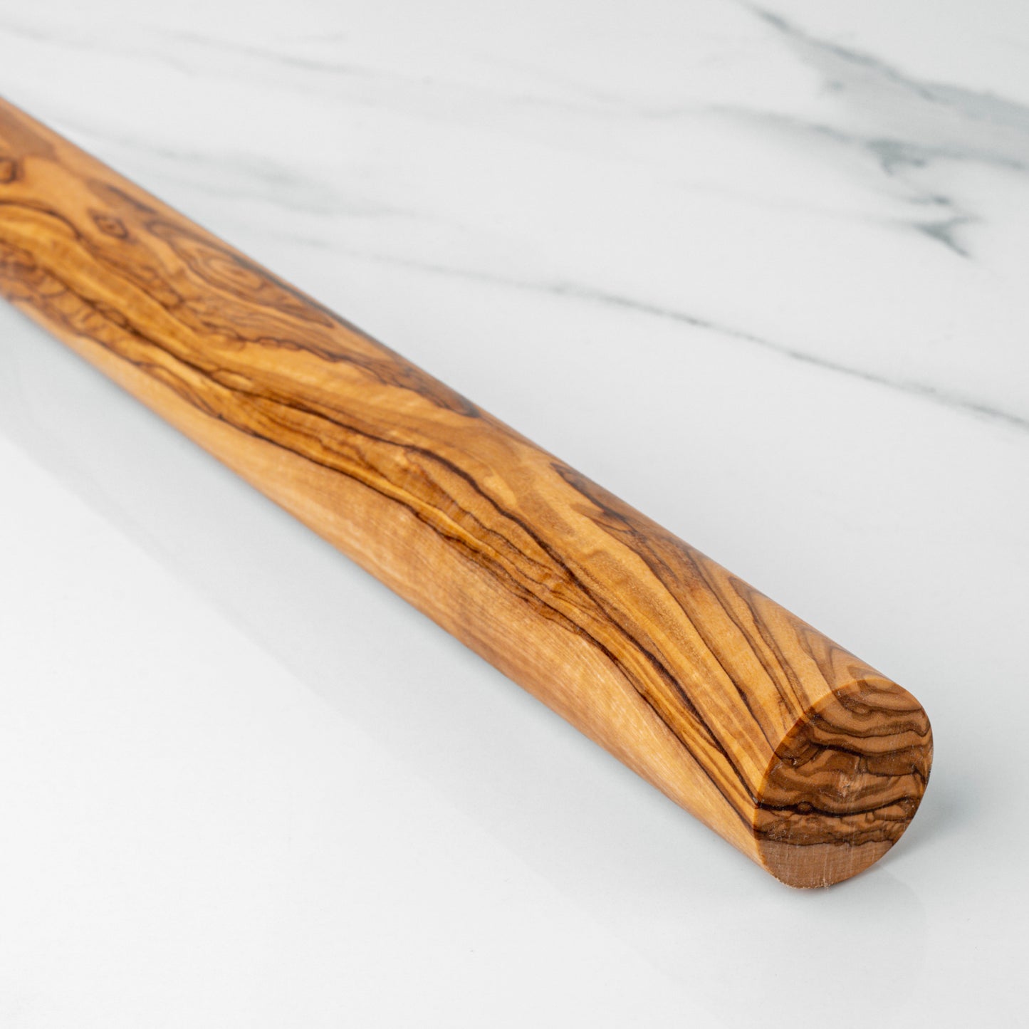Handcrafted olive wood rolling pin on a marble surface, perfect for effortless dough rolling.