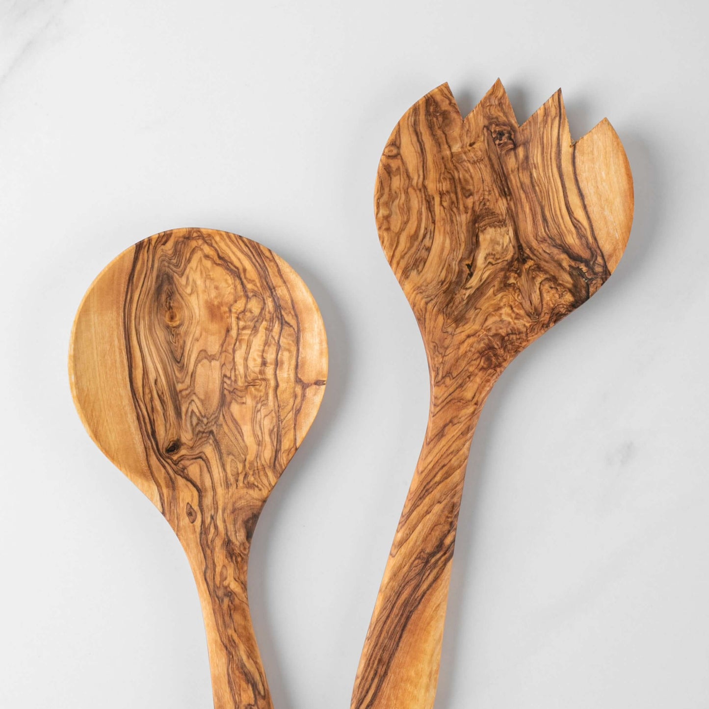 Handmade olive wood salad serving set featuring a round spoon and fork, showcasing unique grain patterns.