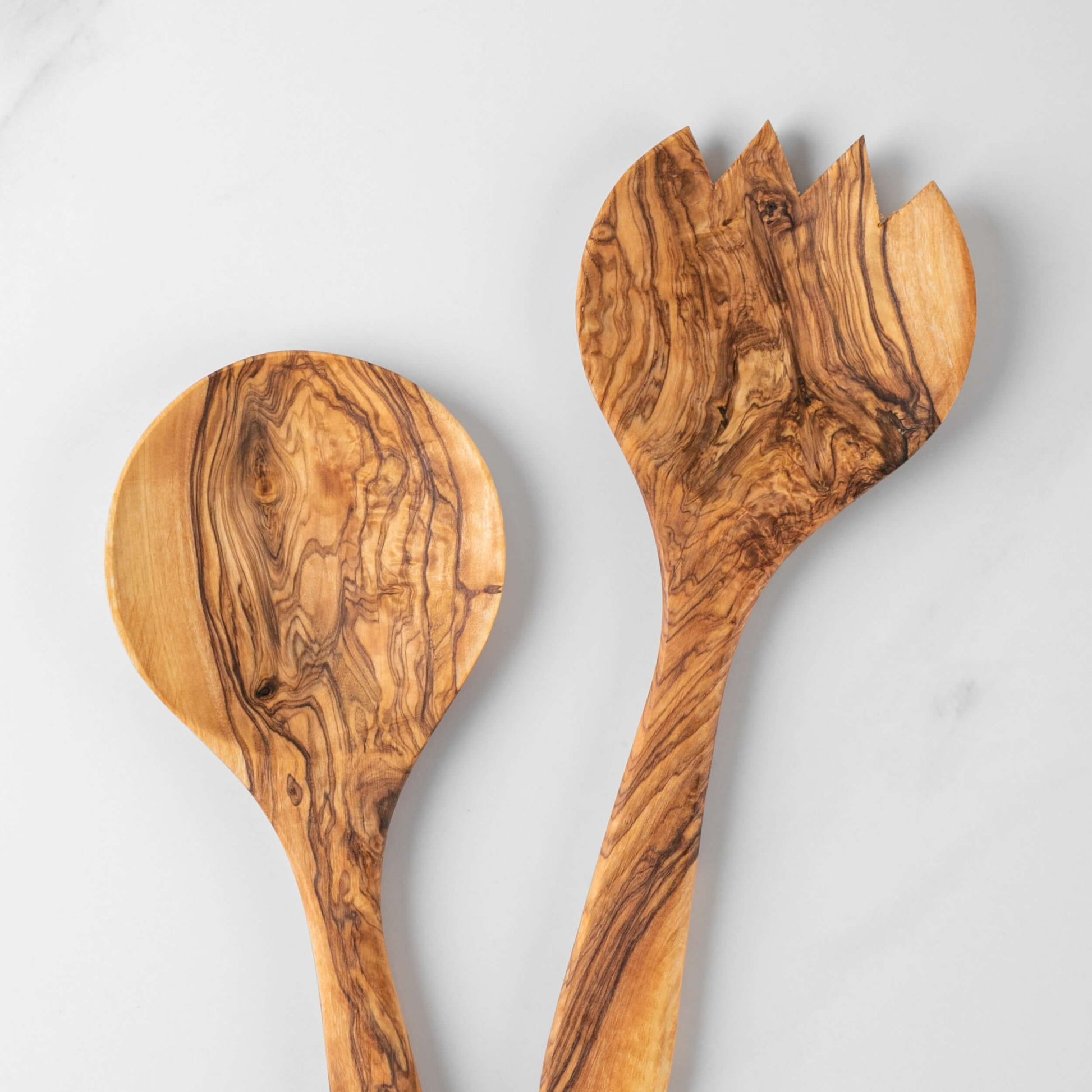 Handmade olive wood salad serving set featuring a round spoon and fork, showcasing unique grain patterns.