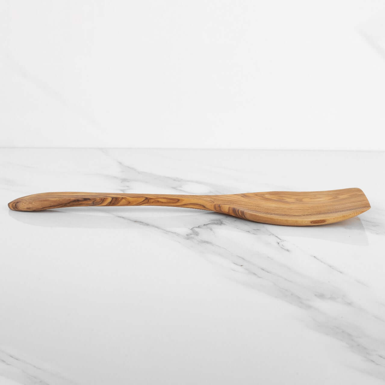 Handmade olive wood shovel spoon with a curved handle, perfect for cooking and serving dishes.