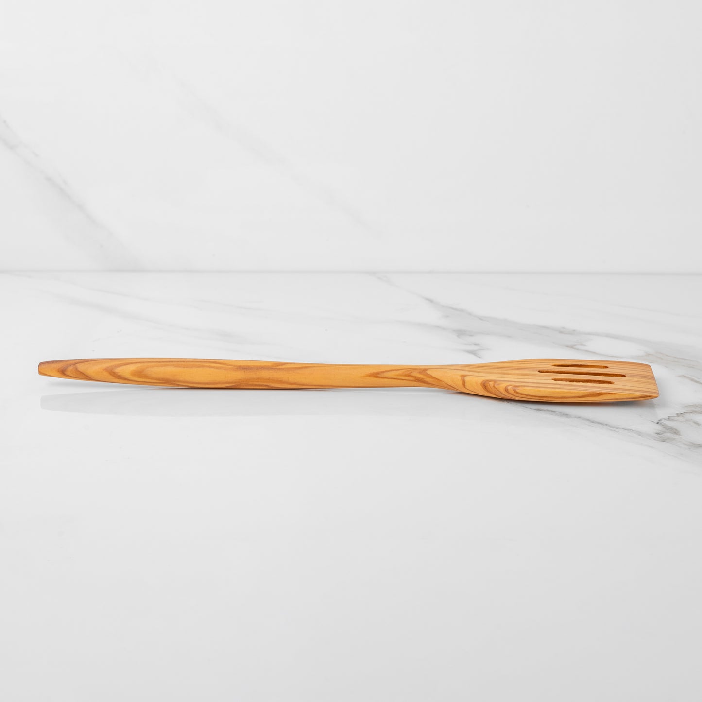 Handmade olive wood slotted spatula, lightweight design, perfect for flipping and stirring in the kitchen.