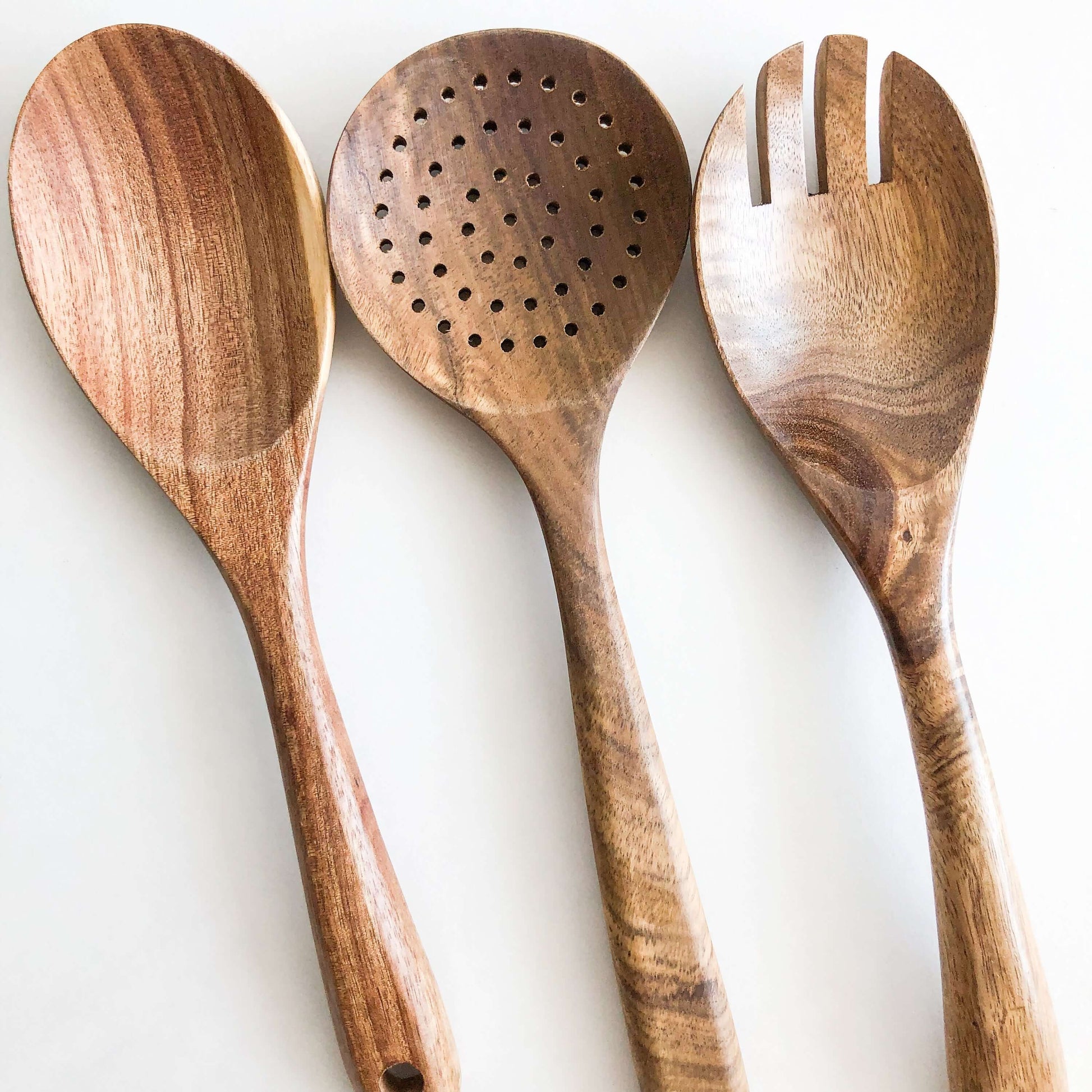 Natural acacia wood kitchen utensil set featuring a spoon, slotted spoon, and fork, perfect for non-stick cookware.
