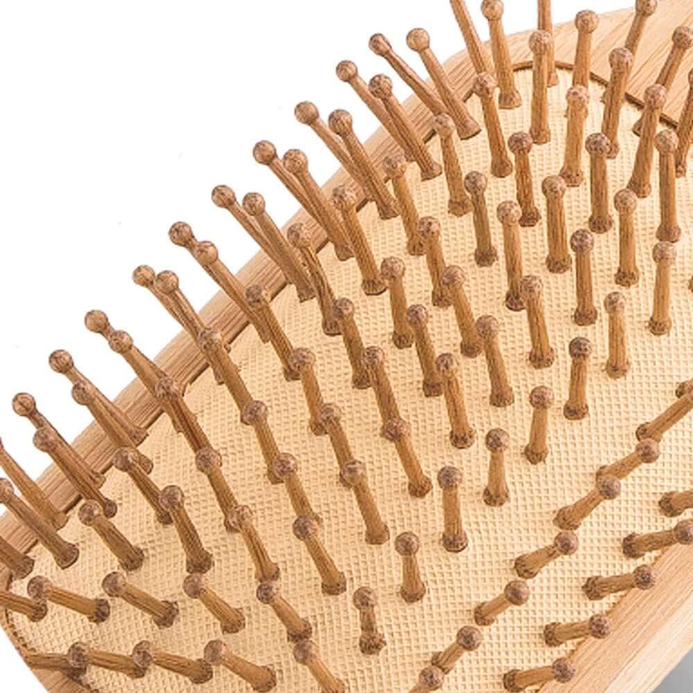 Natural bamboo hair brush with bristles designed to detangle hair and reduce static, eco-friendly and plastic-free.
