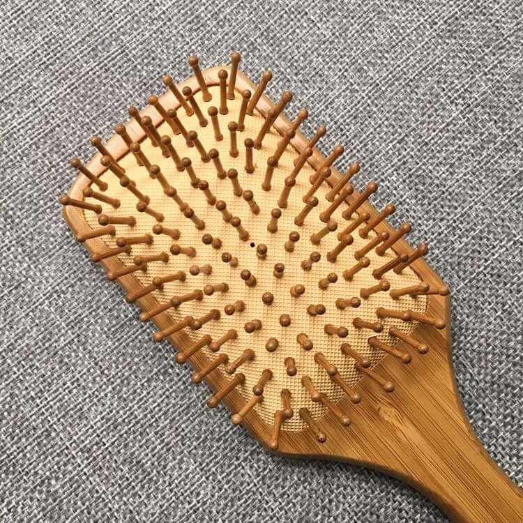 Natural bamboo hair brush with detangling bristles for reducing static and frizz, perfect for all hair types.