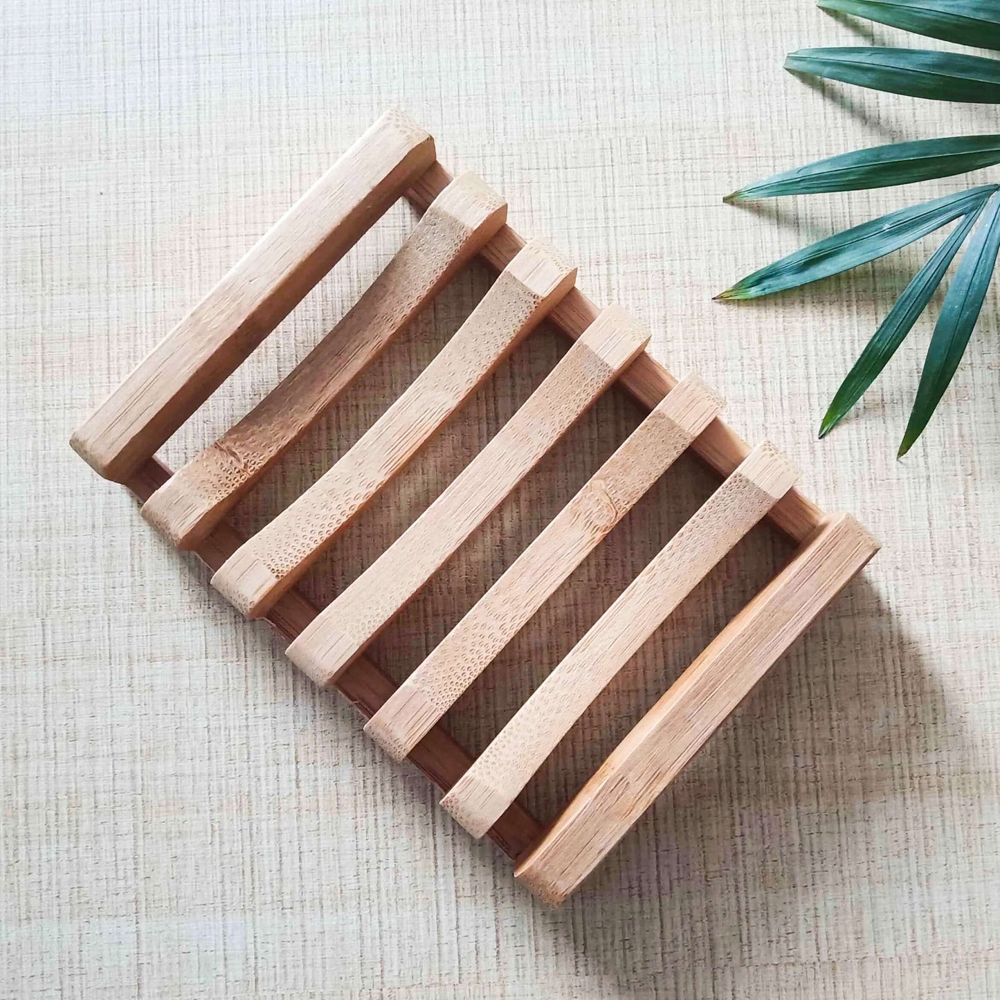 Natural bamboo soap dish on a textured background, promoting eco-friendly, biodegradable living.