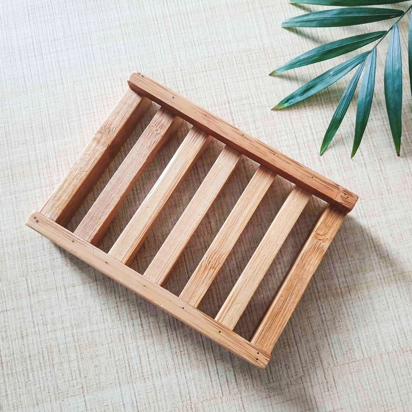Natural bamboo soap dish on a textured surface, promoting an eco-friendly and zero waste lifestyle.
