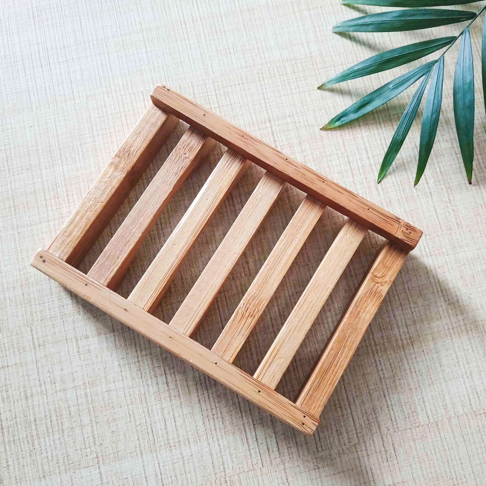 Natural bamboo soap dish on a textured surface, promoting an eco-friendly and zero waste lifestyle.