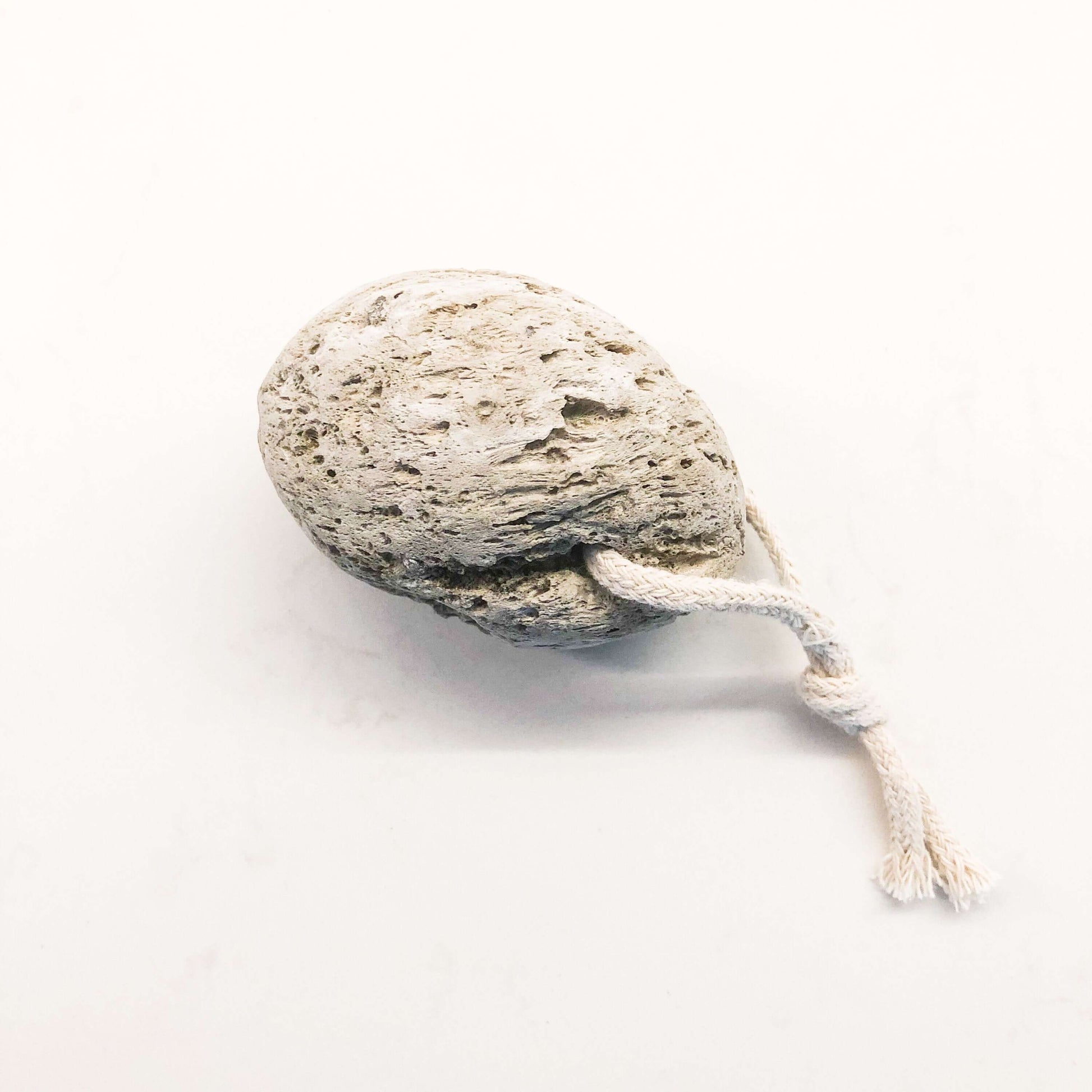 Natural lava stone pumice foot scrubber with rope for easy handling and exfoliating calluses.