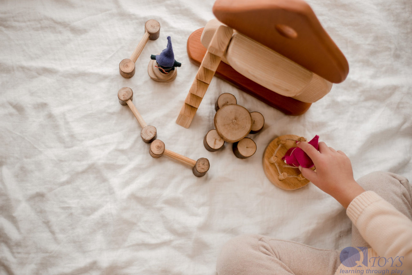 Child playing with Natural Mushroom House, engaging in imaginative play with wooden accessories.