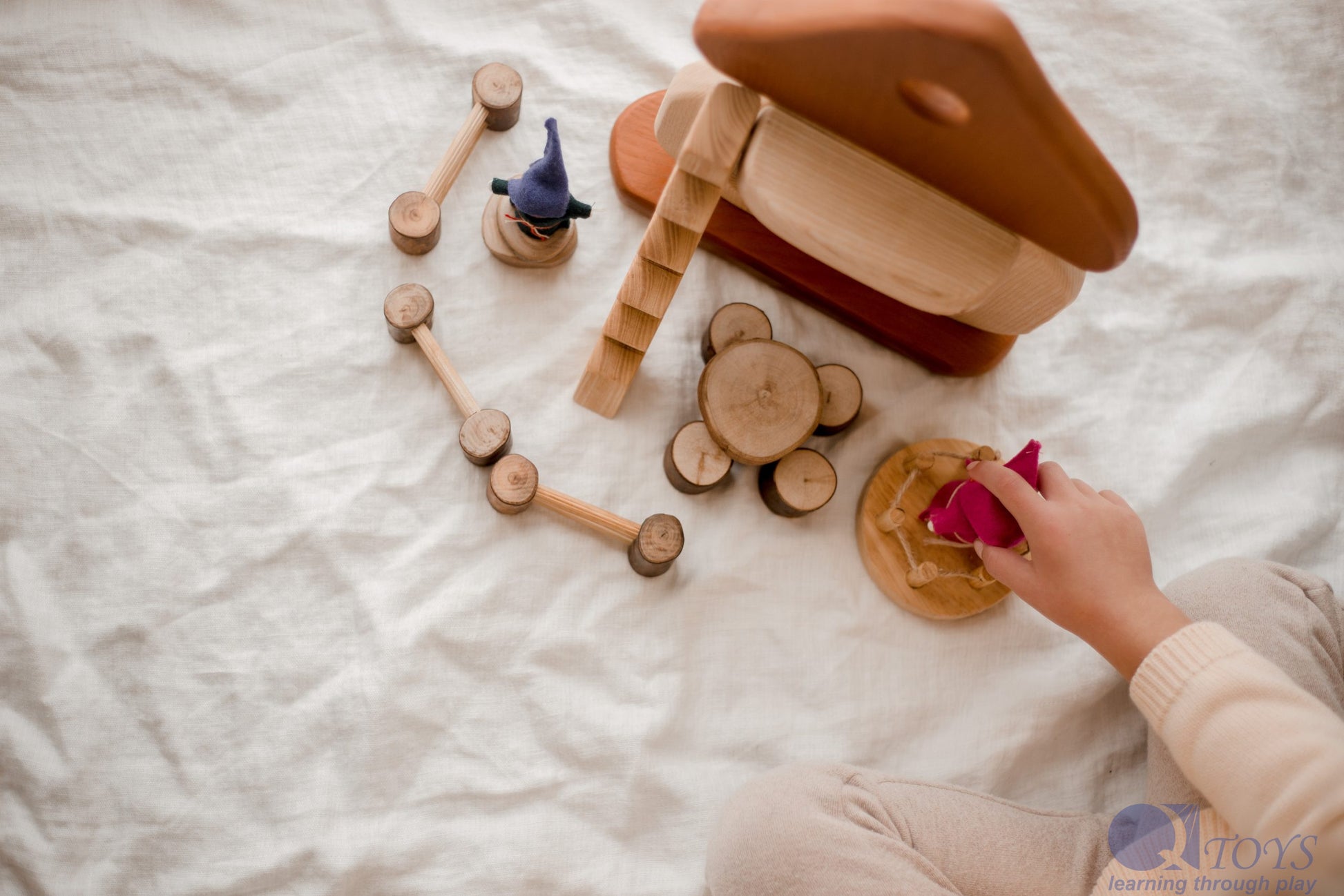 Child playing with Natural Mushroom House, engaging in imaginative play with wooden accessories.