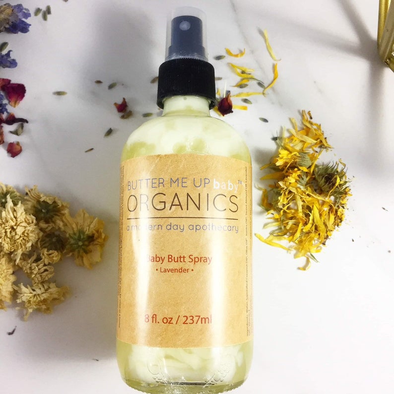 Organic Baby Butt Spray in an 8 oz glass bottle with lavender scent, surrounded by dried flowers.