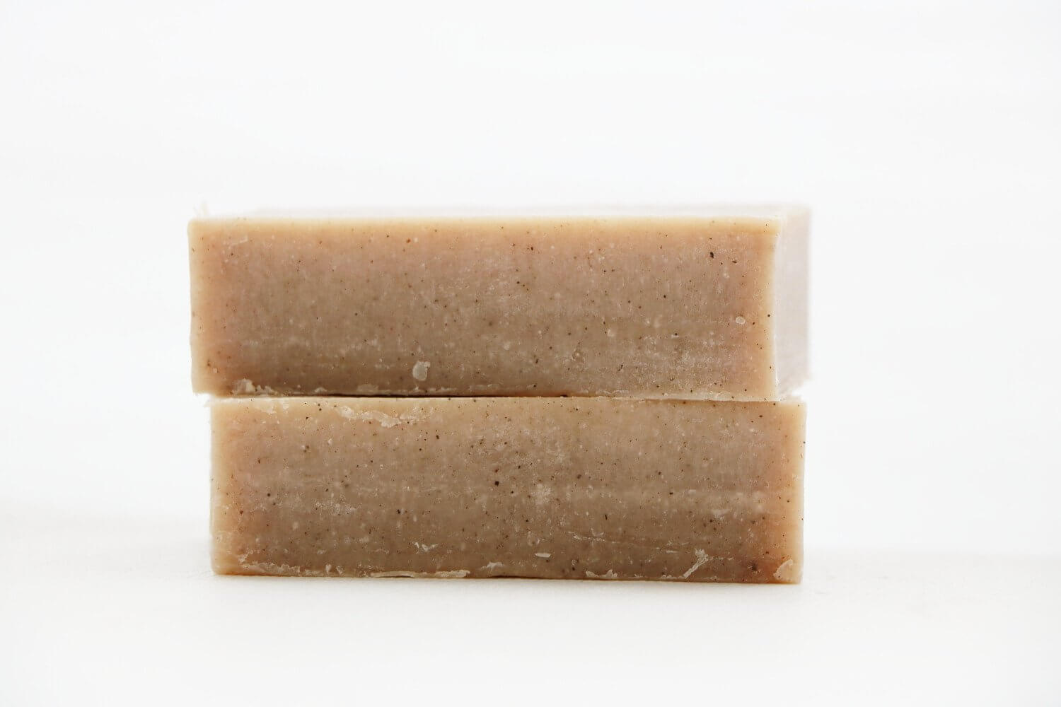 Two natural Peppermint Cream Soap bars stacked, showcasing creamy texture and earthy tones.