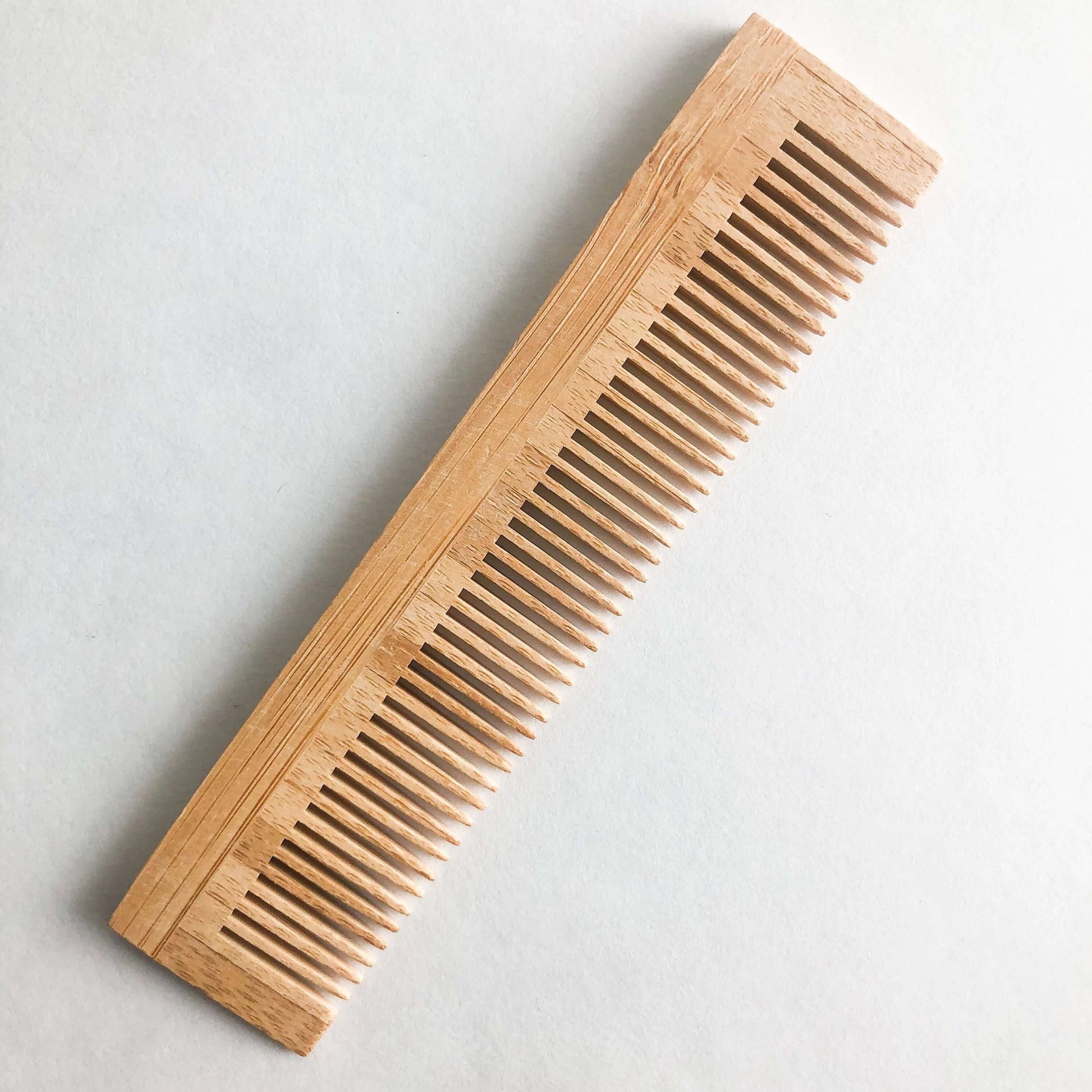 Plastic free natural bamboo comb with fine teeth, ideal for all hair types and gentle on scalp.
