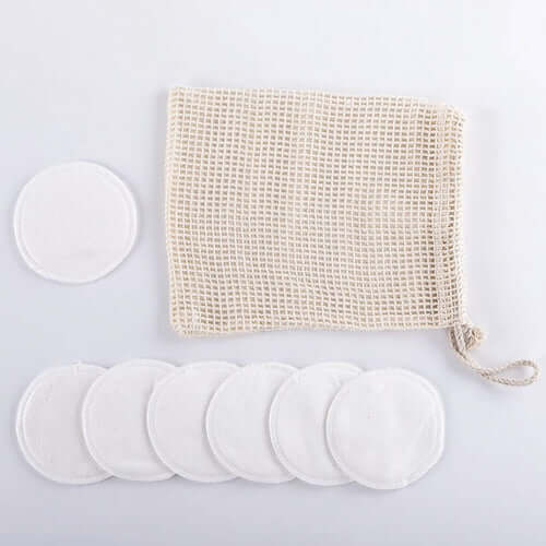 Reusable organic bamboo cotton facial pads and mesh bag for eco-friendly skincare.