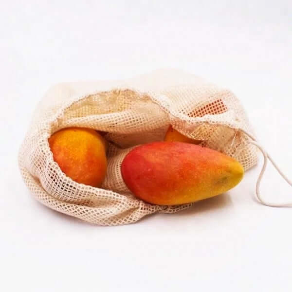 Reusable organic cotton mesh produce bag with mangoes inside, perfect for eco-friendly shopping.