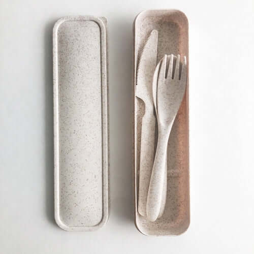 Eco-friendly reusable wheat straw cutlery set in a case, including knife, fork, and spoon.