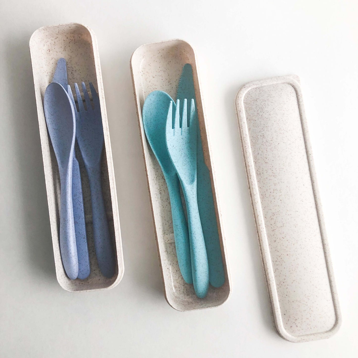 Eco-friendly reusable wheat straw cutlery set in a compact case, featuring blue and teal utensils.