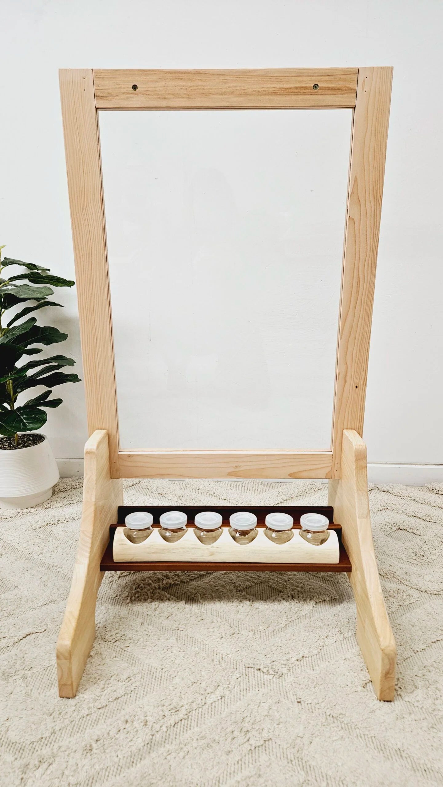 Toddler Perspex easel with wooden frame and paint containers, promoting creativity and motor skills for kids.