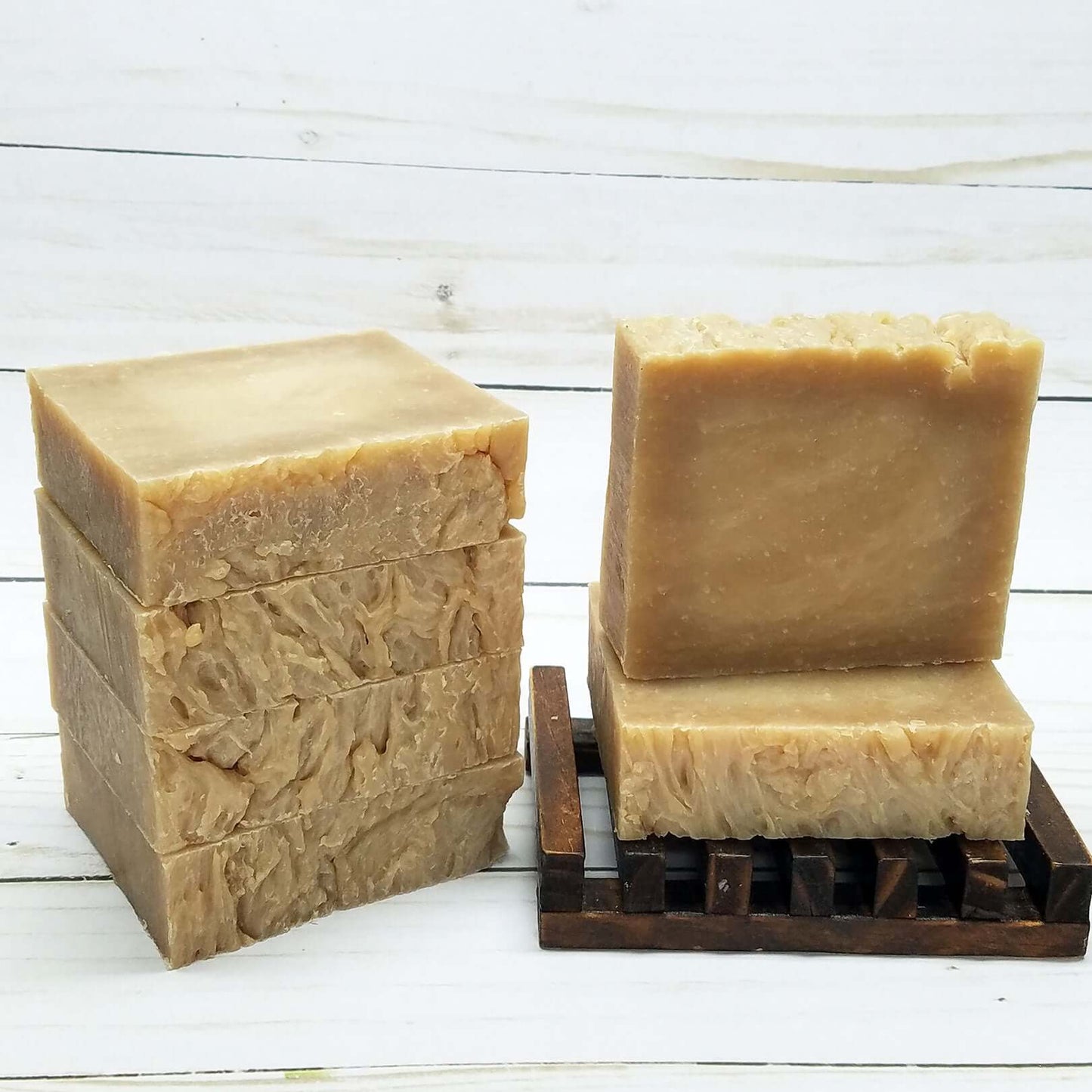 Vegan honey almond handmade soap bars stacked on a wooden drying rack, ideal for nourishing dry skin.