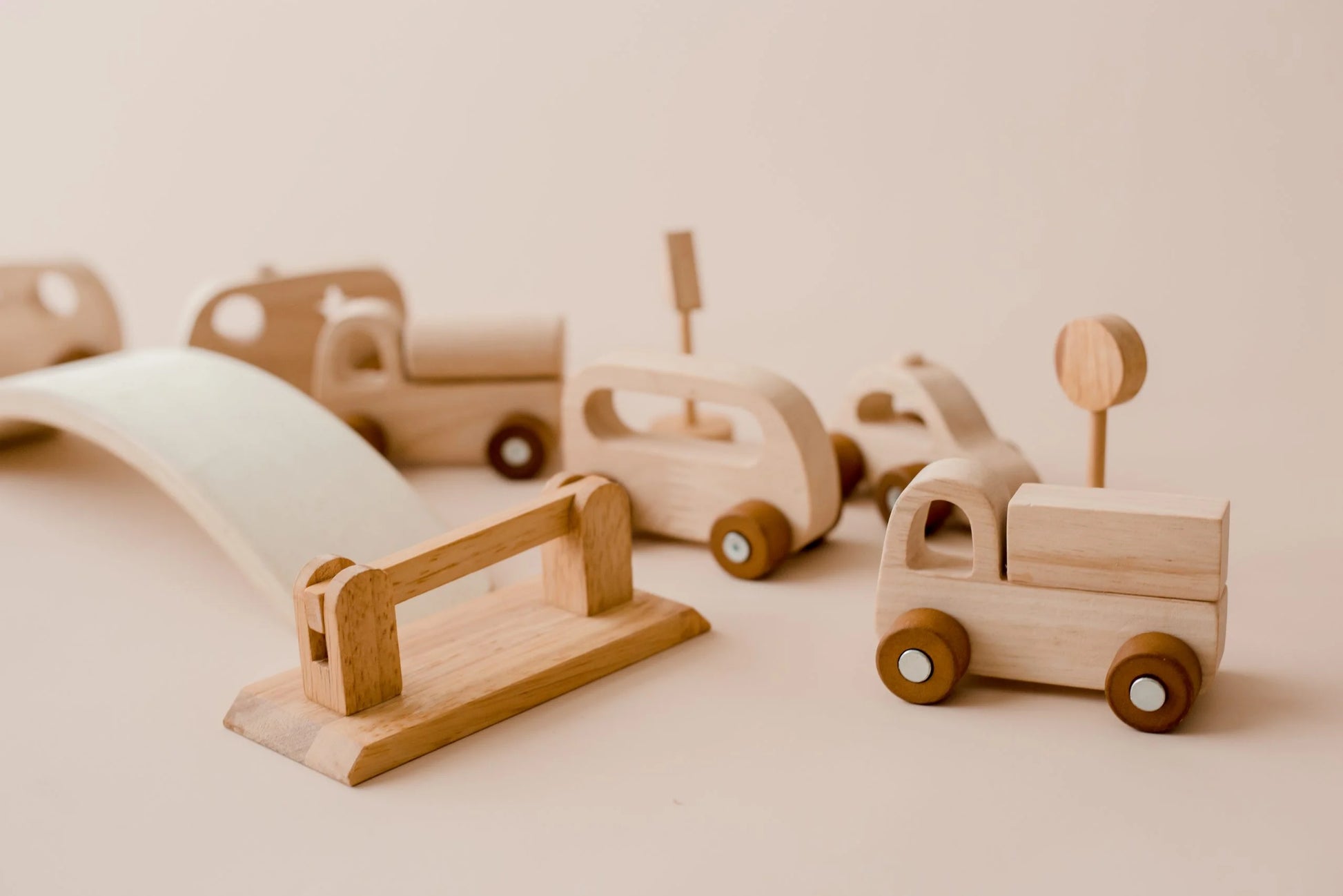 Wooden vehicle play set featuring trucks, traffic signs, and a bridge for imaginative play and road safety learning.