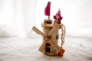 Wooden windmill toy with spinning blades and colorful flags, promoting imaginative play and STEM learning for toddlers.