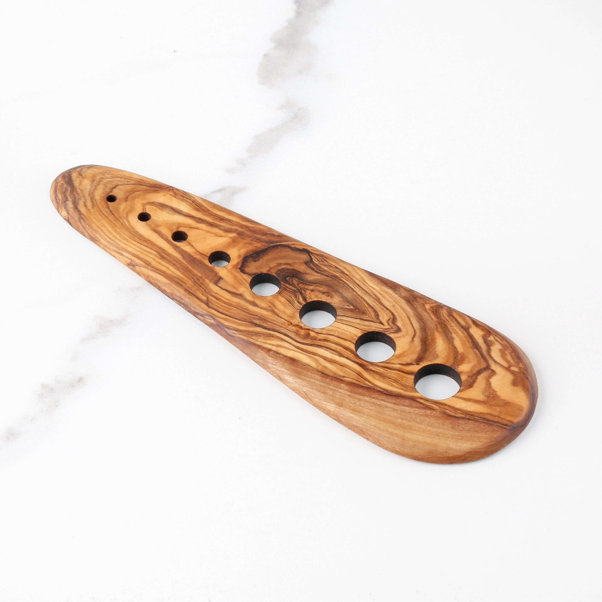 Handmade olive wood herb stripper featuring 8 holes for easy leaf removal of herbs like rosemary and thyme.