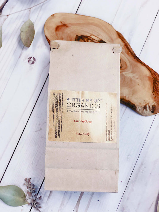 Butter Me Up Organics laundry soap package, eco-friendly, natural ingredients, 1 lb on wooden background.