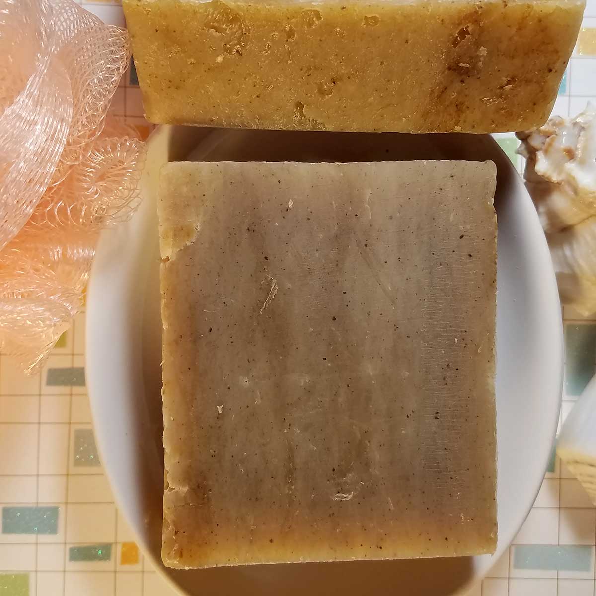 Amber Musk Handmade Soap in earthy tones, showcasing natural colors from Parsley and Turmeric, on a plate.