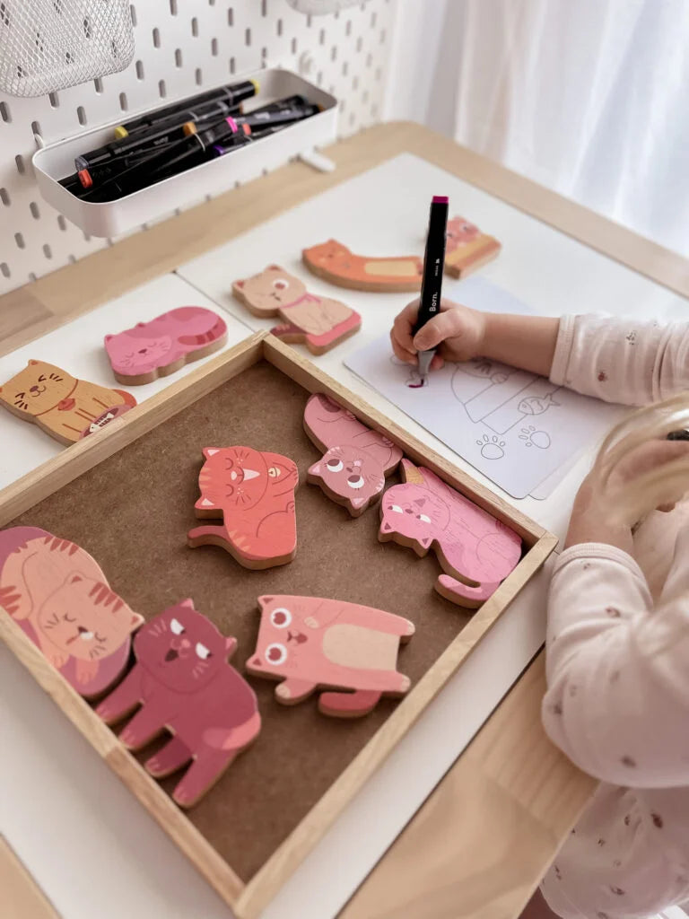 Child coloring with pink wooden cats from the Cat Play Set, fostering creativity and imagination.