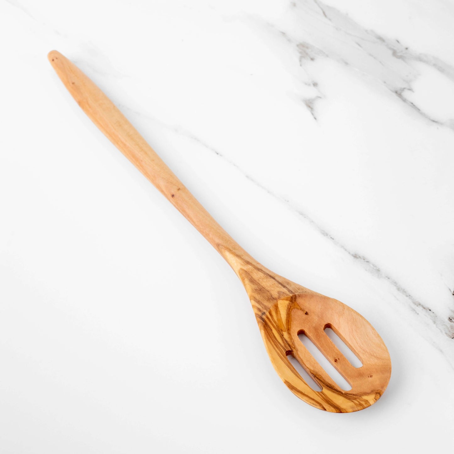 Handmade 35cm olive wood slotted spoon on marble surface, showcasing its elegant design and durable craftsmanship.