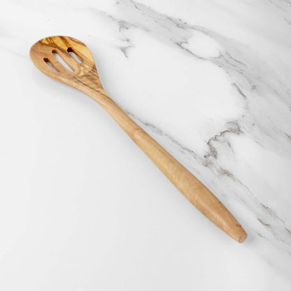 Handmade 35cm olive wood slotted spoon on a marble countertop, ideal for cooking and serving.