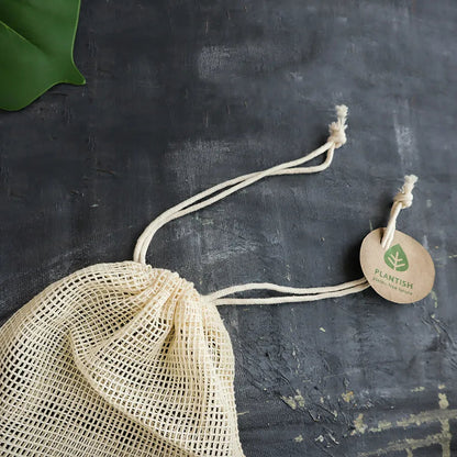 Natural mesh bag for reusable cotton makeup removal rounds with drawstring closure and eco-friendly tag.