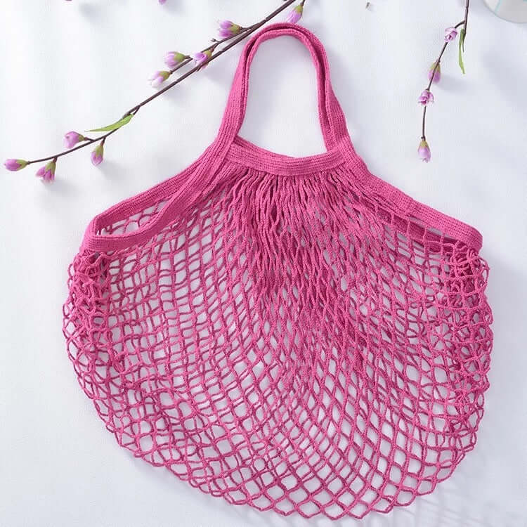 Reusable pink organic cotton mesh bag, perfect for grocery shopping and eco-friendly produce storage.