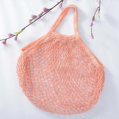 Eco-friendly organic cotton mesh bag in peach, perfect for groceries and produce.
