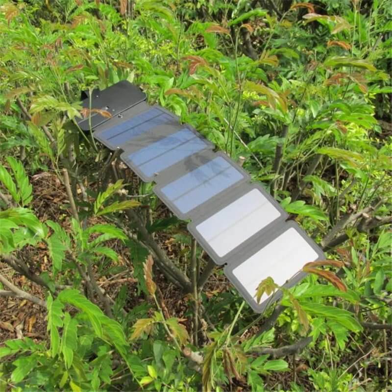 Folding solar charger panels displayed among greenery, ideal for traveling and outdoor adventures.