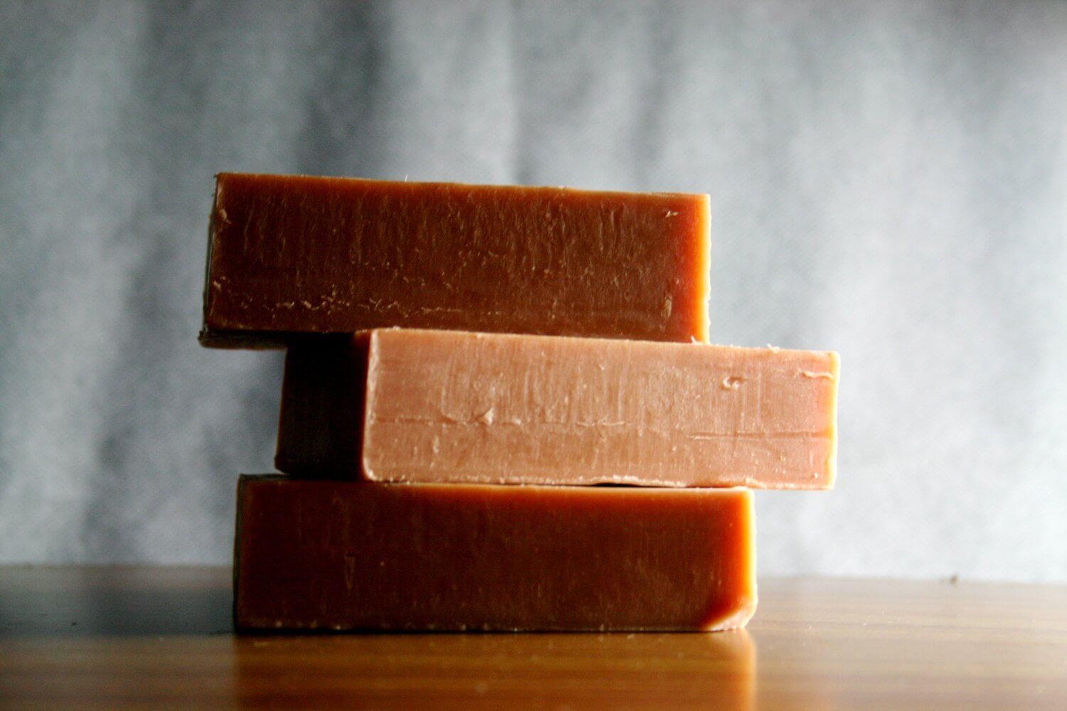 Three stacked bars of French Red Clay Soap for oily skin, showcasing a smooth texture and natural color.