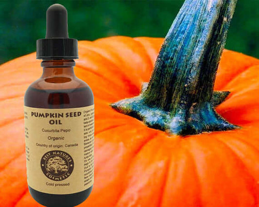 Organic Pumpkin Seed Oil bottle in front of a vibrant pumpkin, highlighting natural cold-pressed skincare benefits.